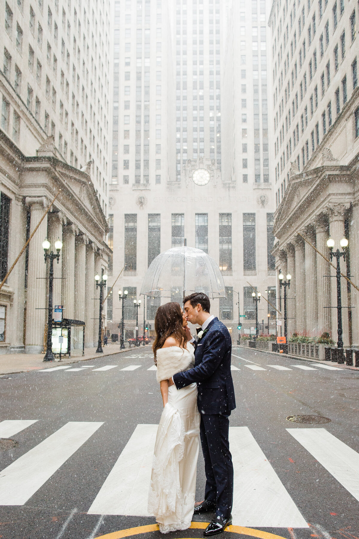 A Chicago wedding photographer captures a couple in the middle of a downtown street during a snow storm