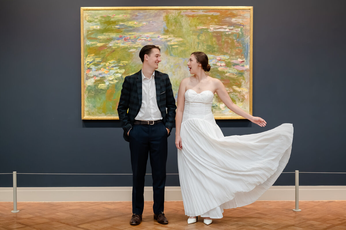 A couple stand in front of a painting
