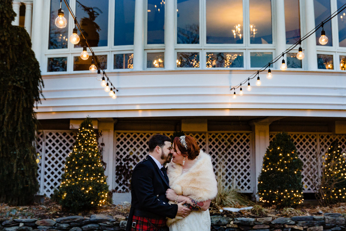 The newlyweds hold each other close with a warm fall backdrop behind them at their Waterville Valley Resort wedding in NH