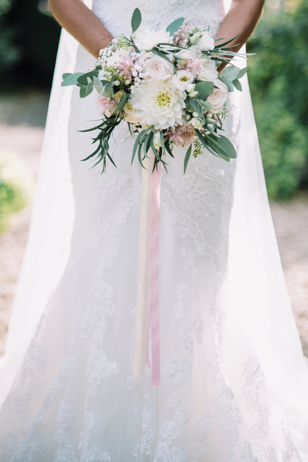 A bride holding her bouquet and waist height taken by London Wedding Photographer Liberty Pearl