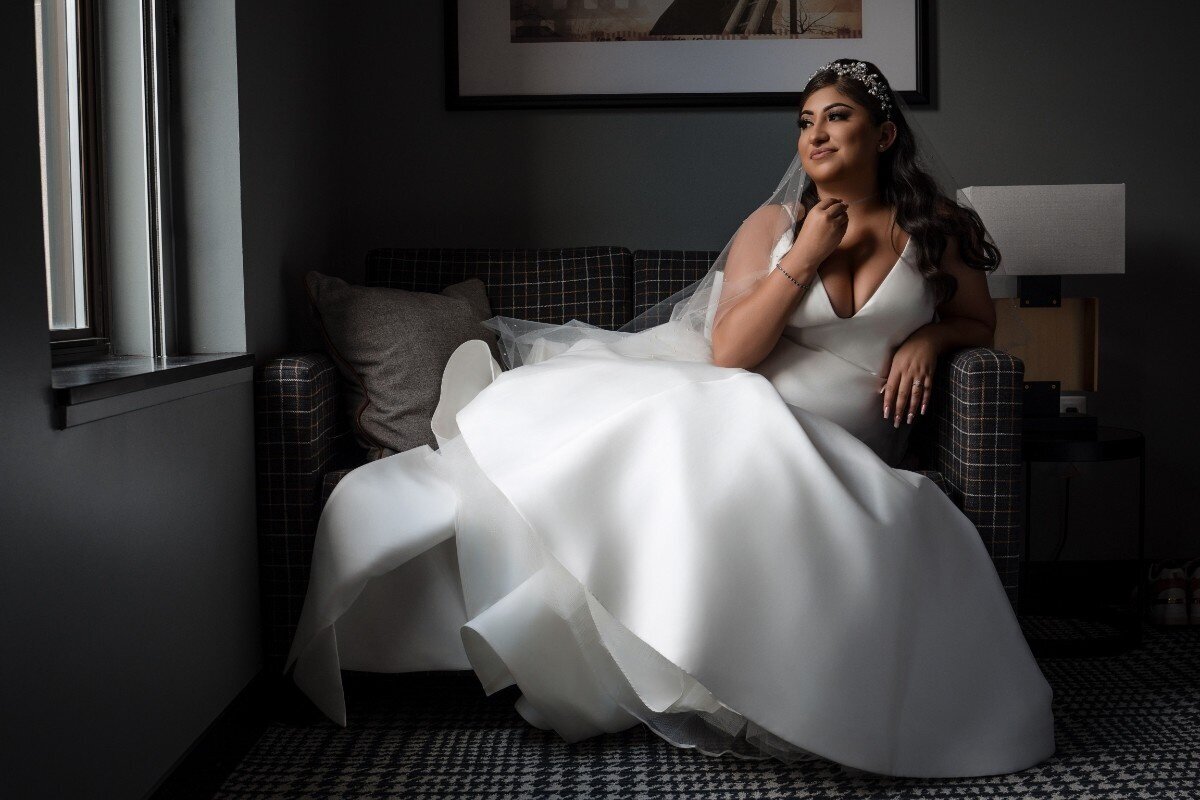 Bride gazing out the window in elegant bridal gown