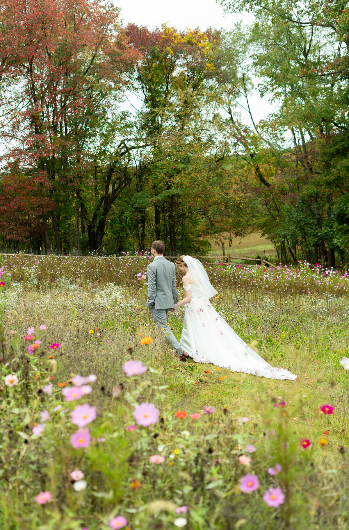 couple walking through the wildflowers after outdoor ceremony at Lavender Ridge in Columbus