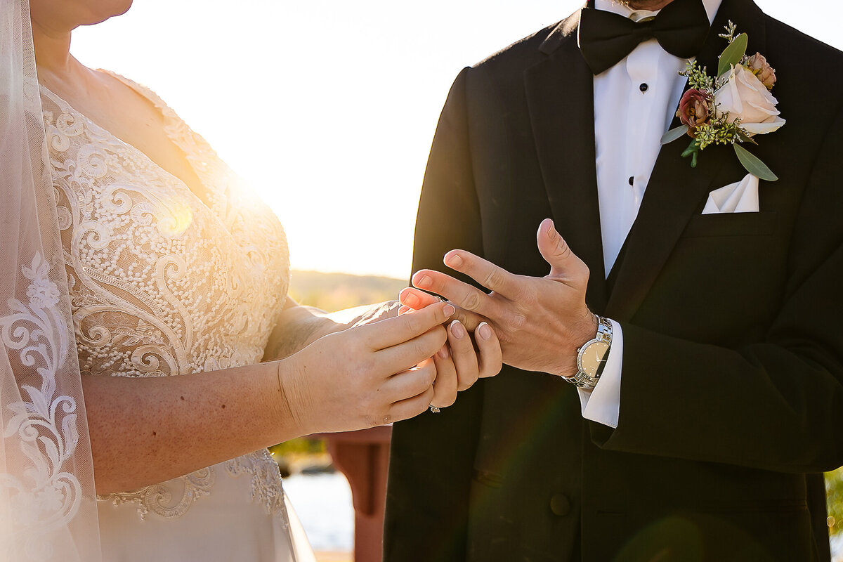 bride placing ring on grooms finger during wedding ceremony at Pembroke Pines Country Club in New Hampshire