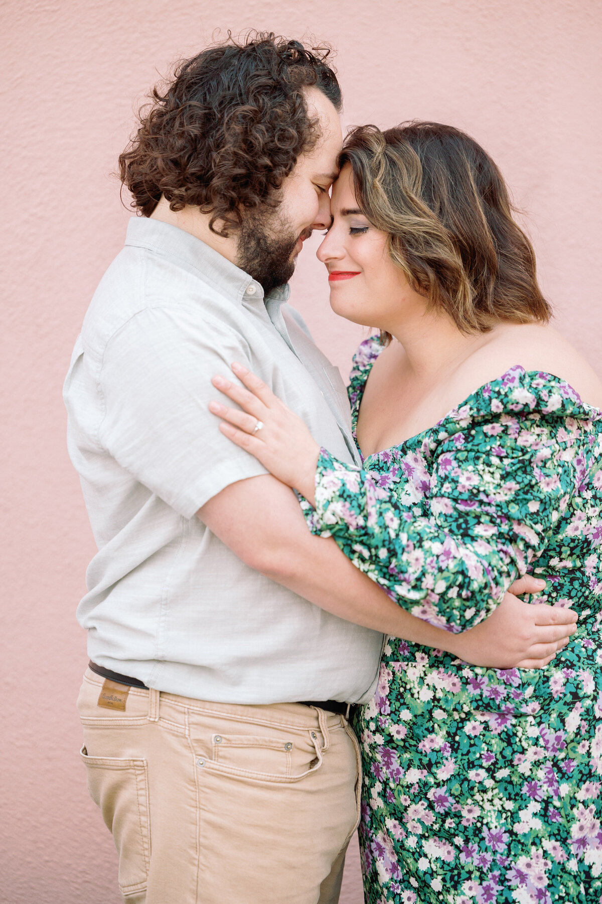 A couple standing forehead to forehead smiling