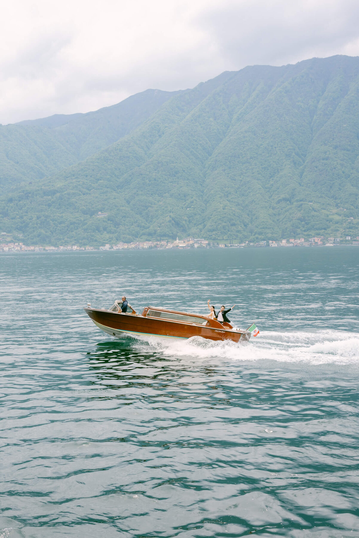 A wedding photo of the couple on a boat on the way to their wedding venue Villa Balbiano