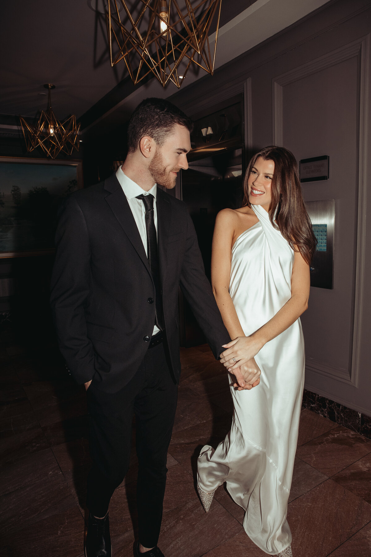 bride and groom hand in hand at the hotel leveque during their engagement shoot