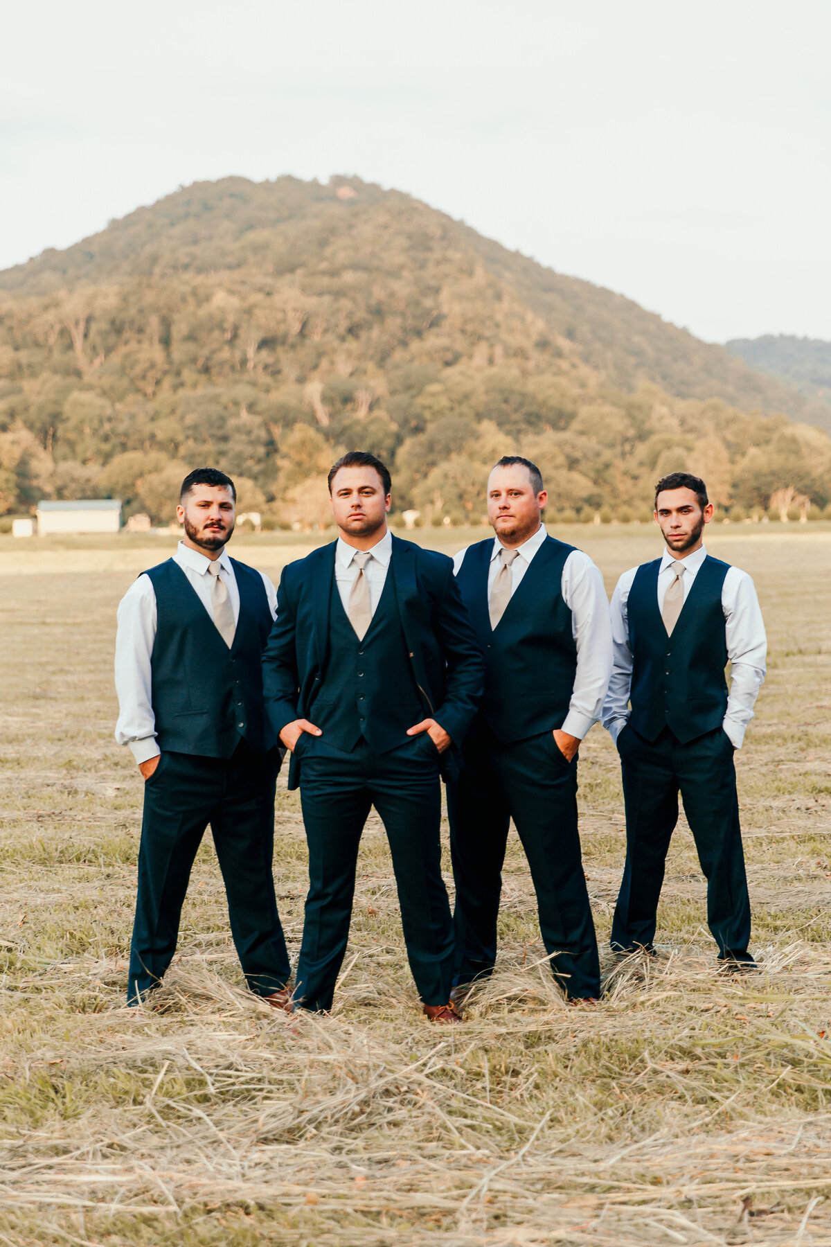 groom and groomsmen in front of a mountain