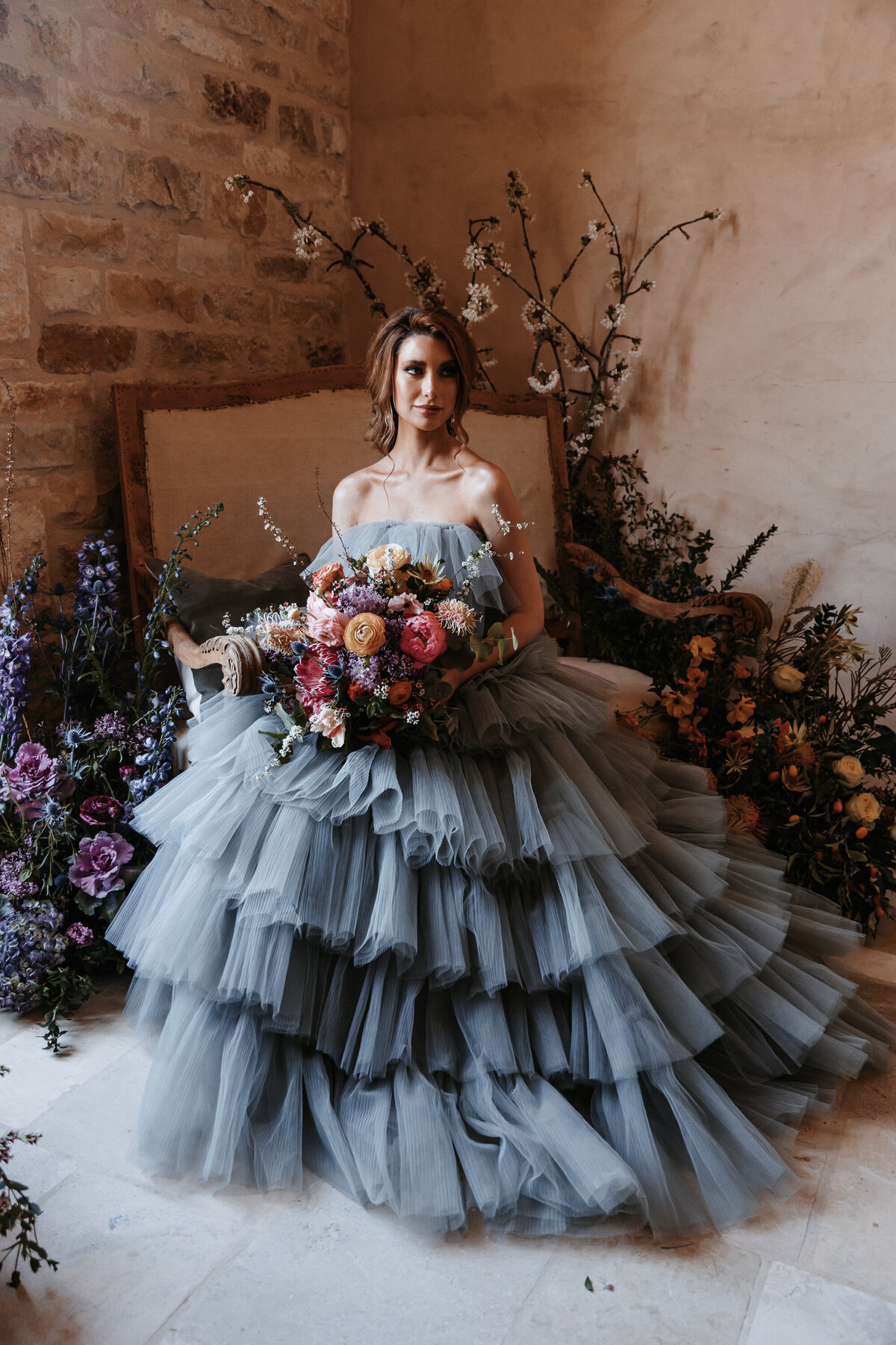 Elopement photography, bridal portrait in blue puffy gown surrounded by flowers holding a bouquet