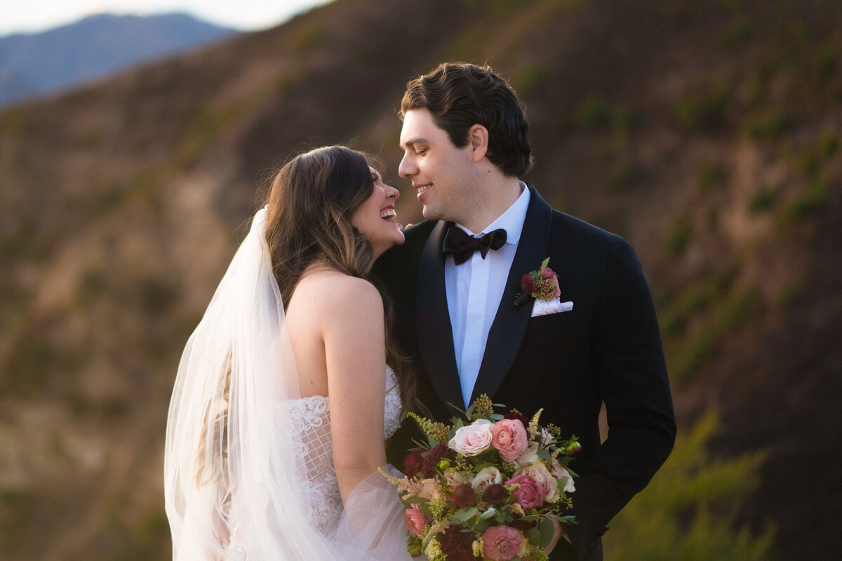 Bride and groom smile at eachother