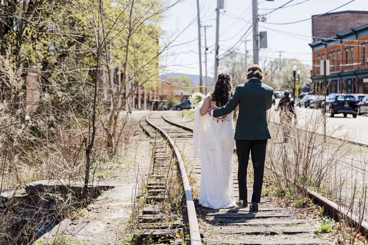Bride and groom walk along the train tracks in Beacon NY by the Roundhouse wedding venue