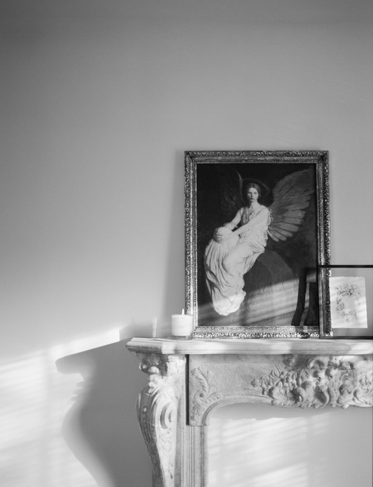 ornate stone mantle with angel painting, simple candle, candle company branding photography, lifestyle