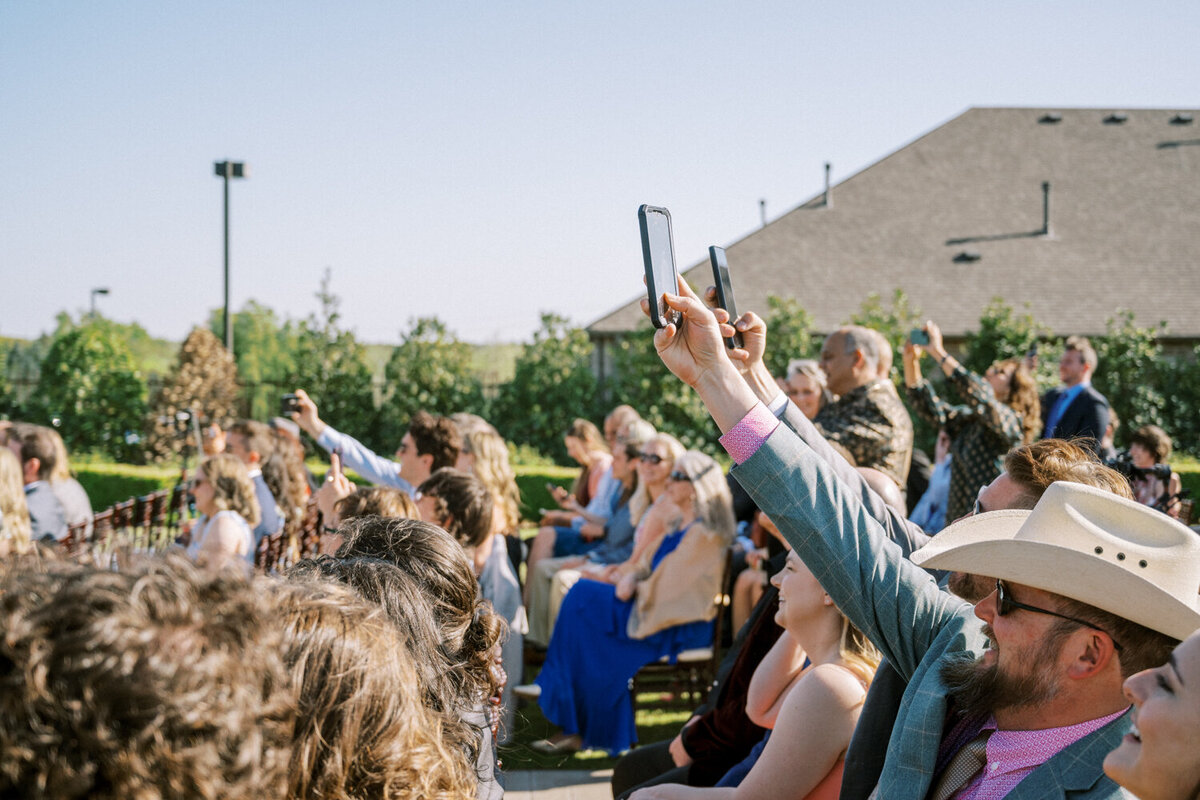 tons-of-guests-hold-up-cellphones-to-take-photo-during-ceremony