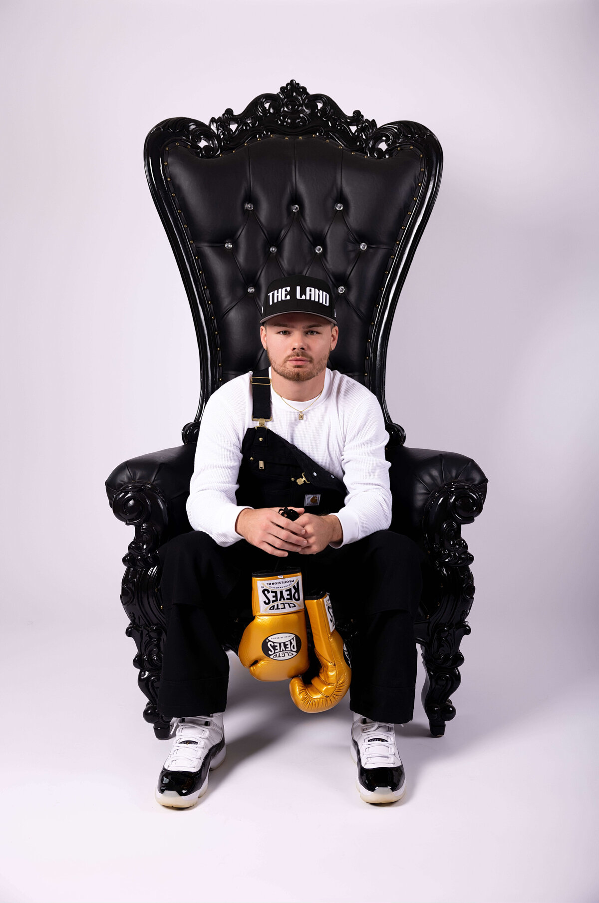 Professional boxer sitting in chair with boxing gloves in birthday session with Reva Davis photography