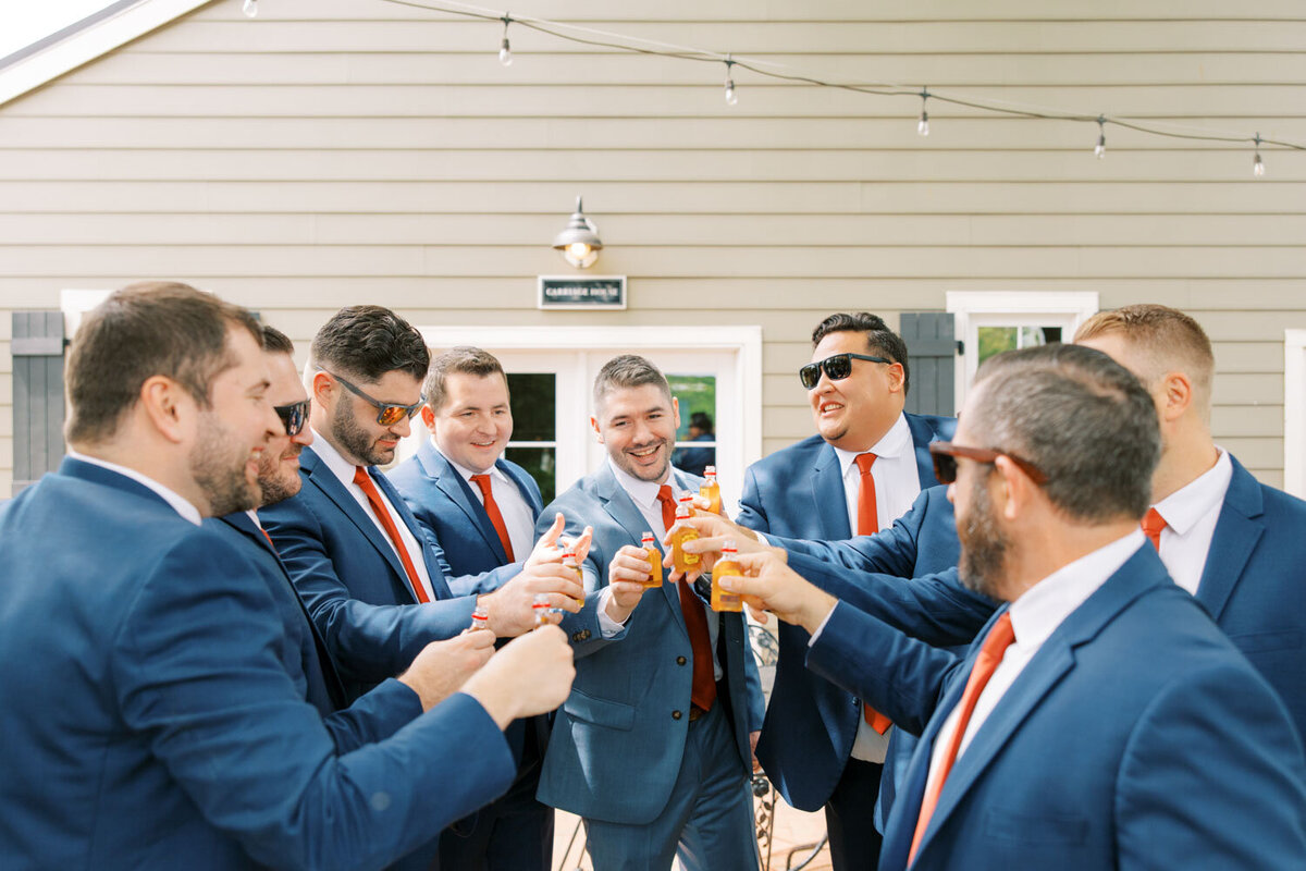 Groom and groomsmen tossing their drinks