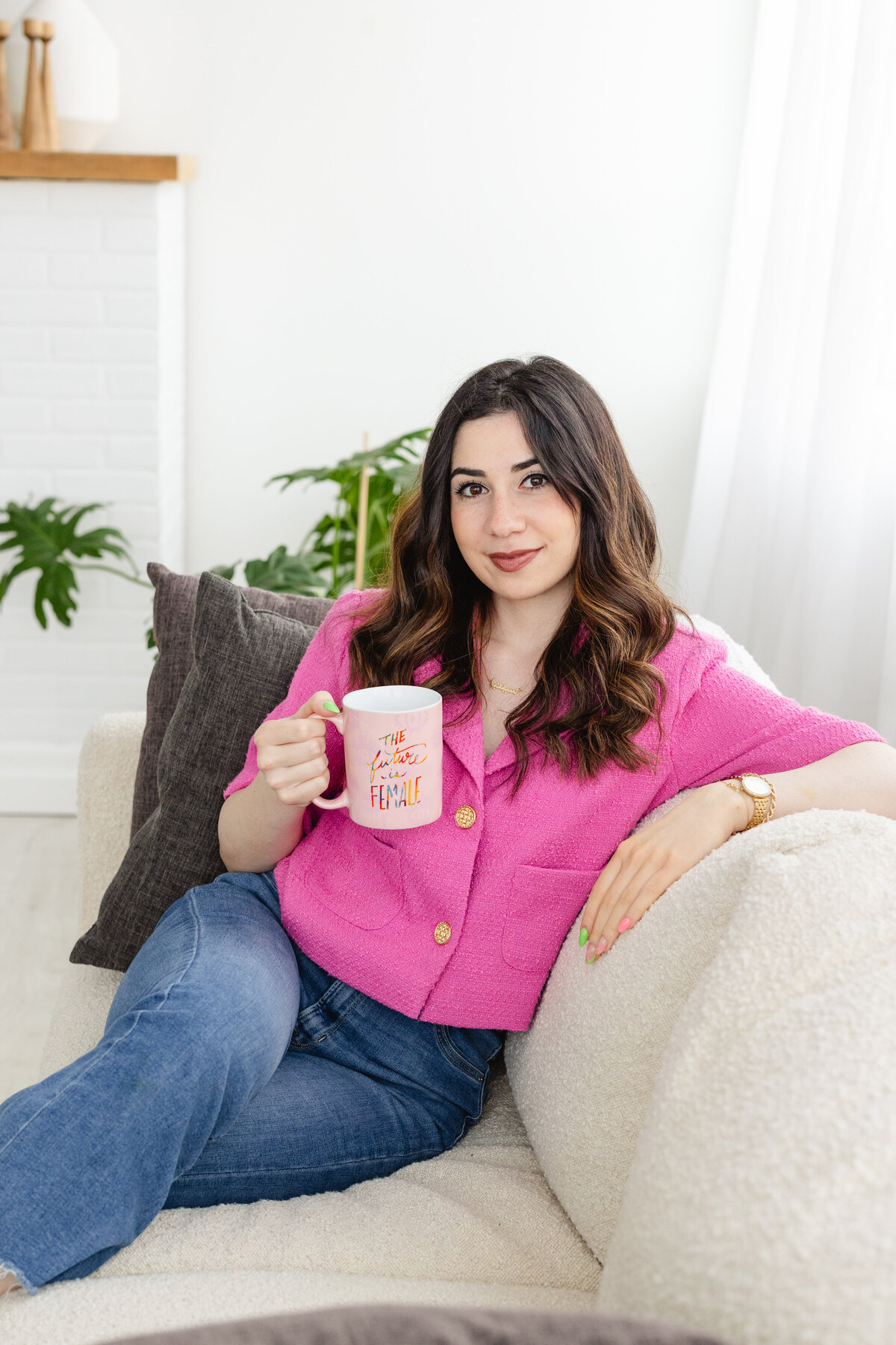 Cynthia lounging at the couch while holding her mug of coffee.
