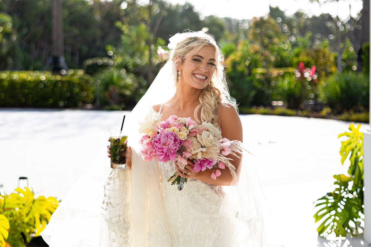 Brenda looking radiant, holding a pink and white floral bouquet before her beach wedding at Cheeca Lodge.