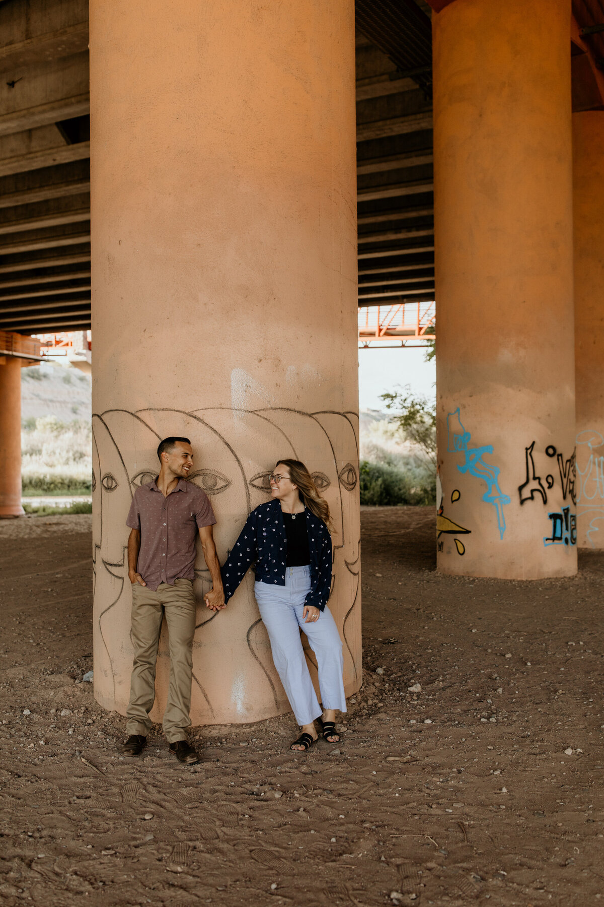 couple standing against a pillar under an overpass in Albuquerque