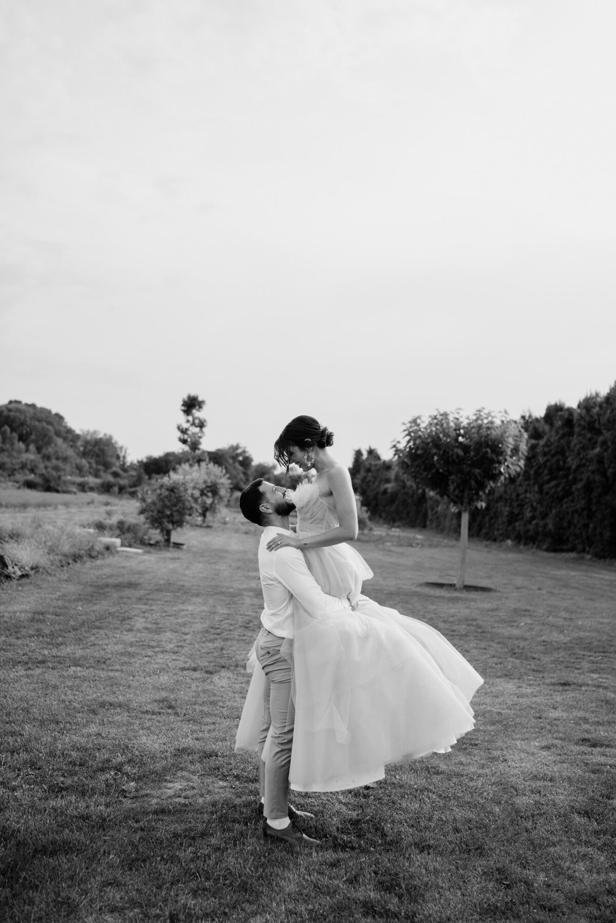 Groom-carrying-his-bride-during-an-outdoor-shoot