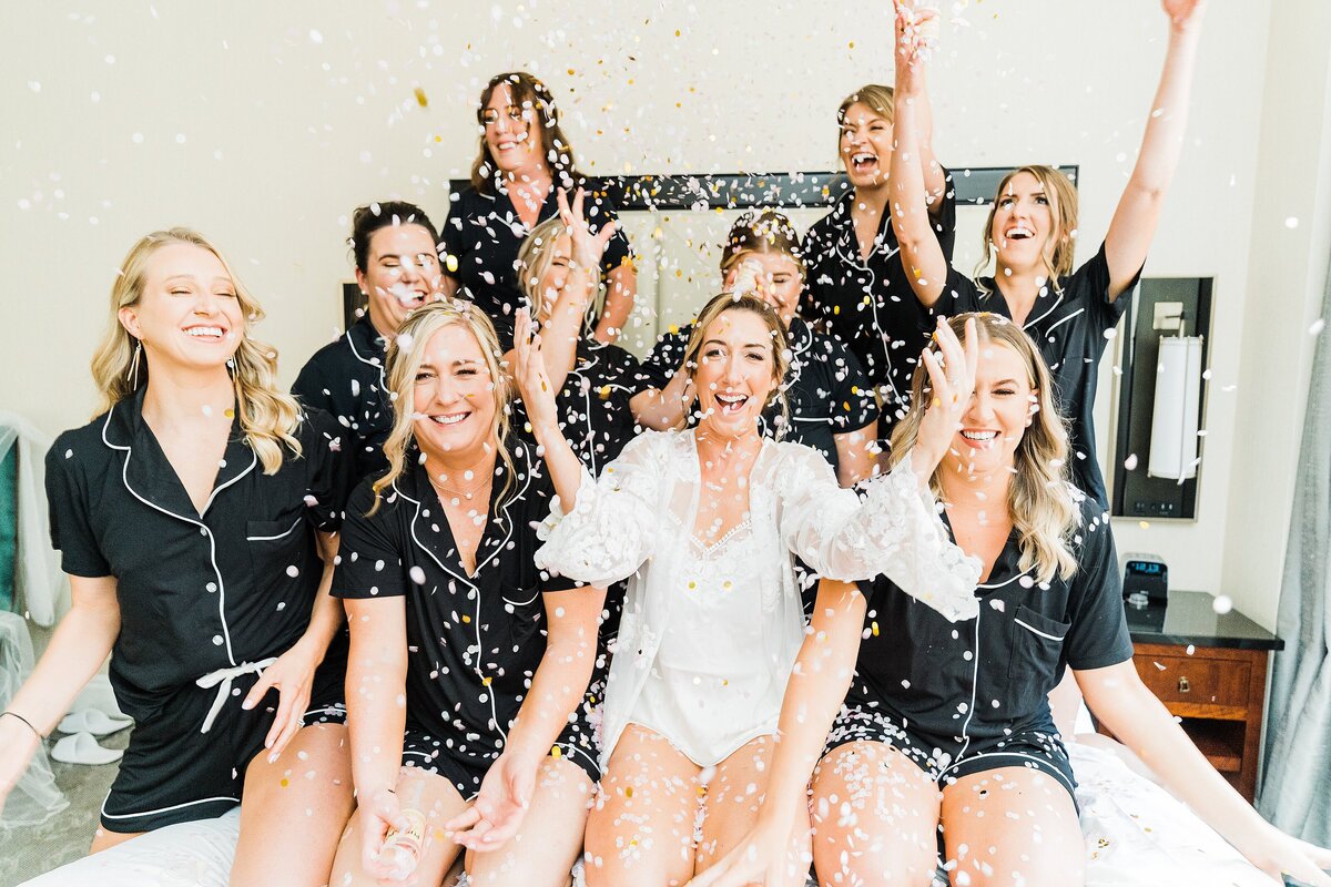 bride and bridesmaids throwing flowers in air confetti