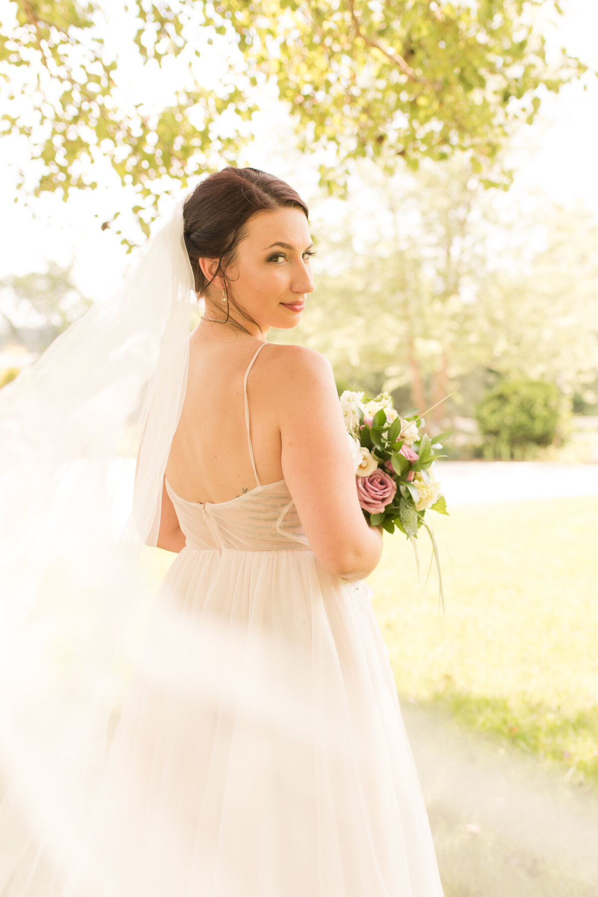 back of a wedding dress with bride looking over her shoulder