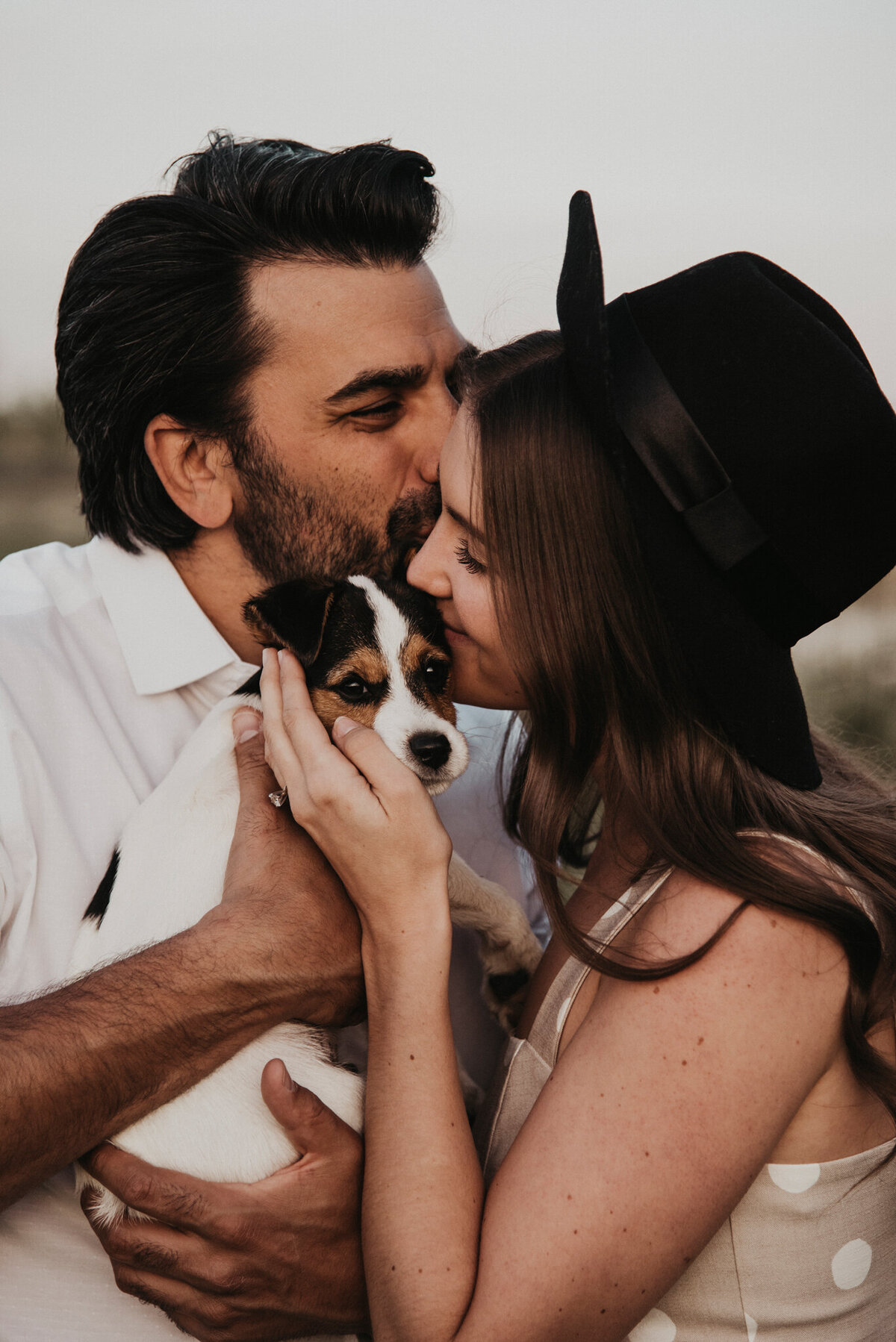Adorable engagement session inspiration, trendy, modern couple snuggling with dog, captured by Kelsey Vera Photography, intimate and romantic wedding photographer in Airdrie, Alberta. Featured on the Bronte Bride Vendor Guide.