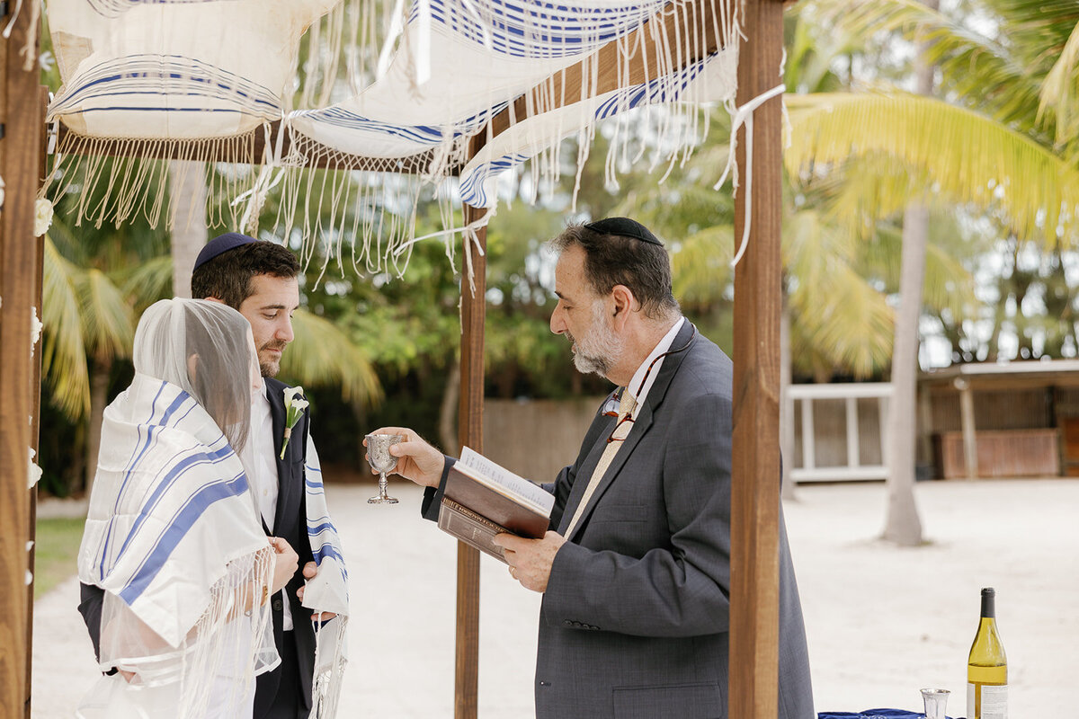  A heartfelt moment as the rabbi blesses Minette and Evan under the chuppah. Islamorada wedding photography by Claudia Amalia.