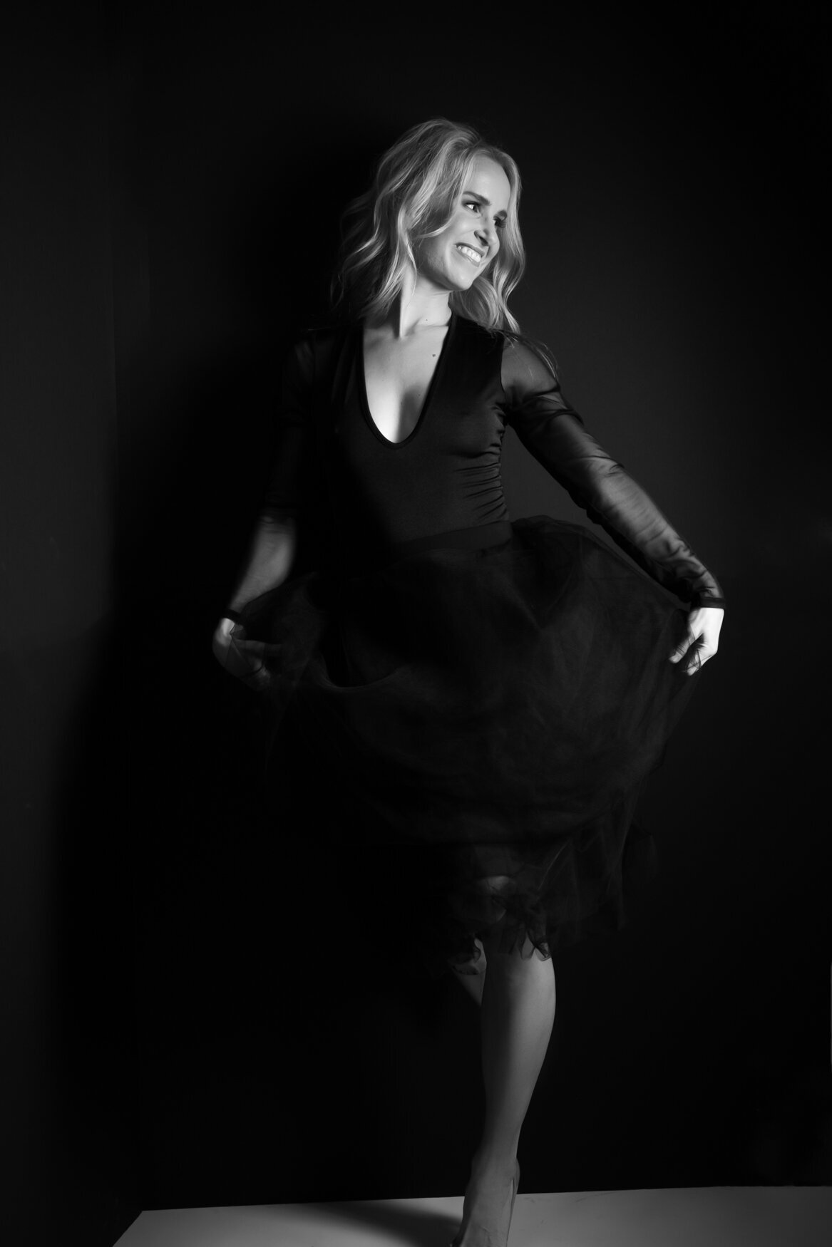 a black and white portrait of a woman wearing a black tulle dress