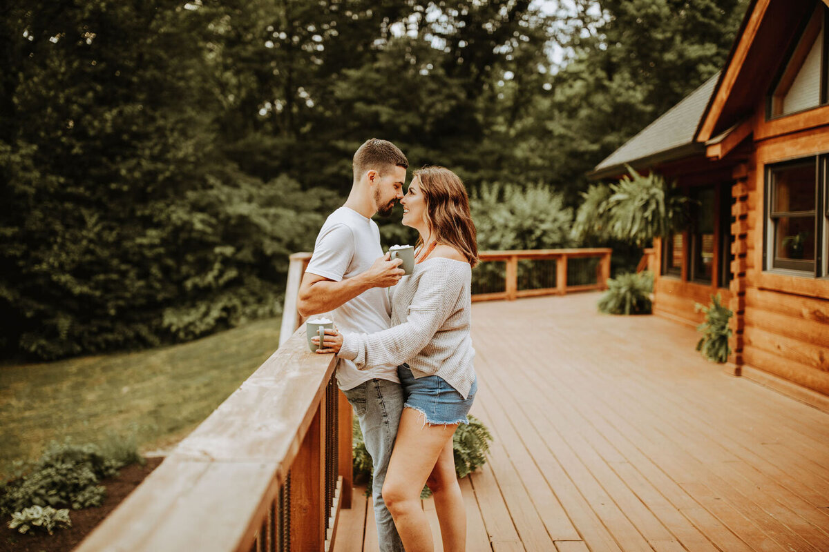 Couple enjoying a moment on a wooden deck surrounded by lush trees