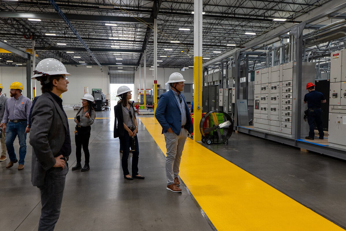 A group of people looking on in a warehouse 