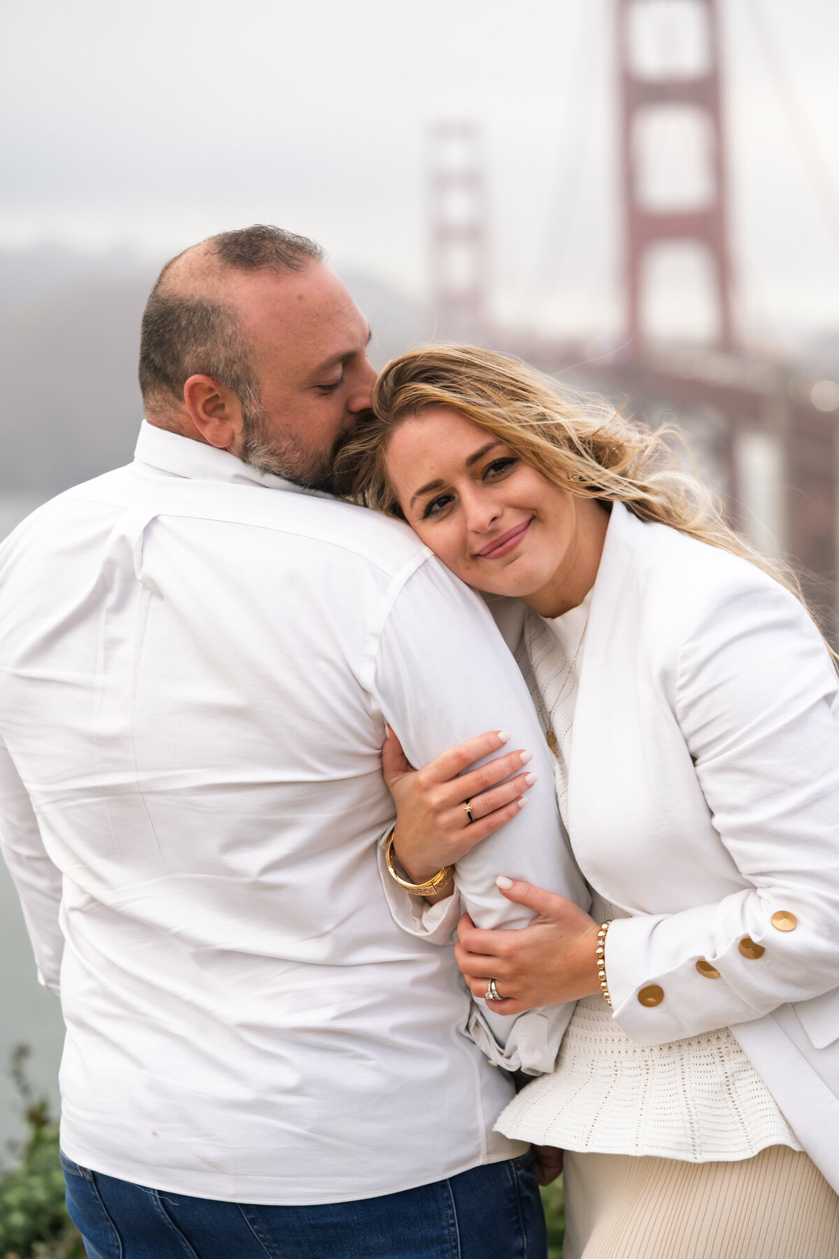 Couple embracing in front of the golden gate bridge