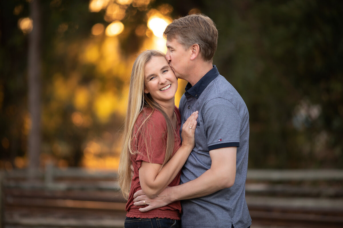 A couple embraces as the Dallas family photographer captures their love against a glowing backdrop.