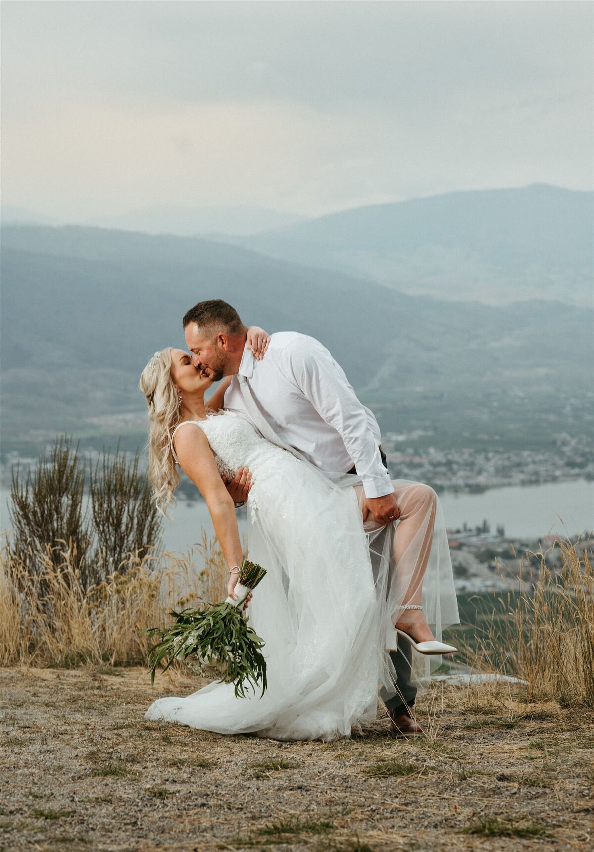 a married couple kissing on top the mountain in osoyoos BC