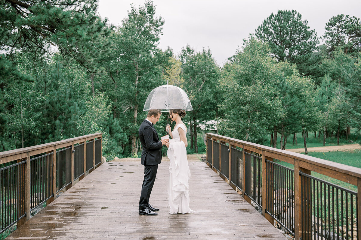 Bride and groom read their vows to each other before their wedding ceremony on a bride at the Landing in Estes Park.