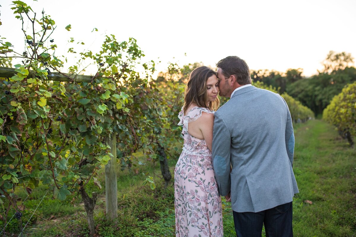 man and woman kissing in vineyard