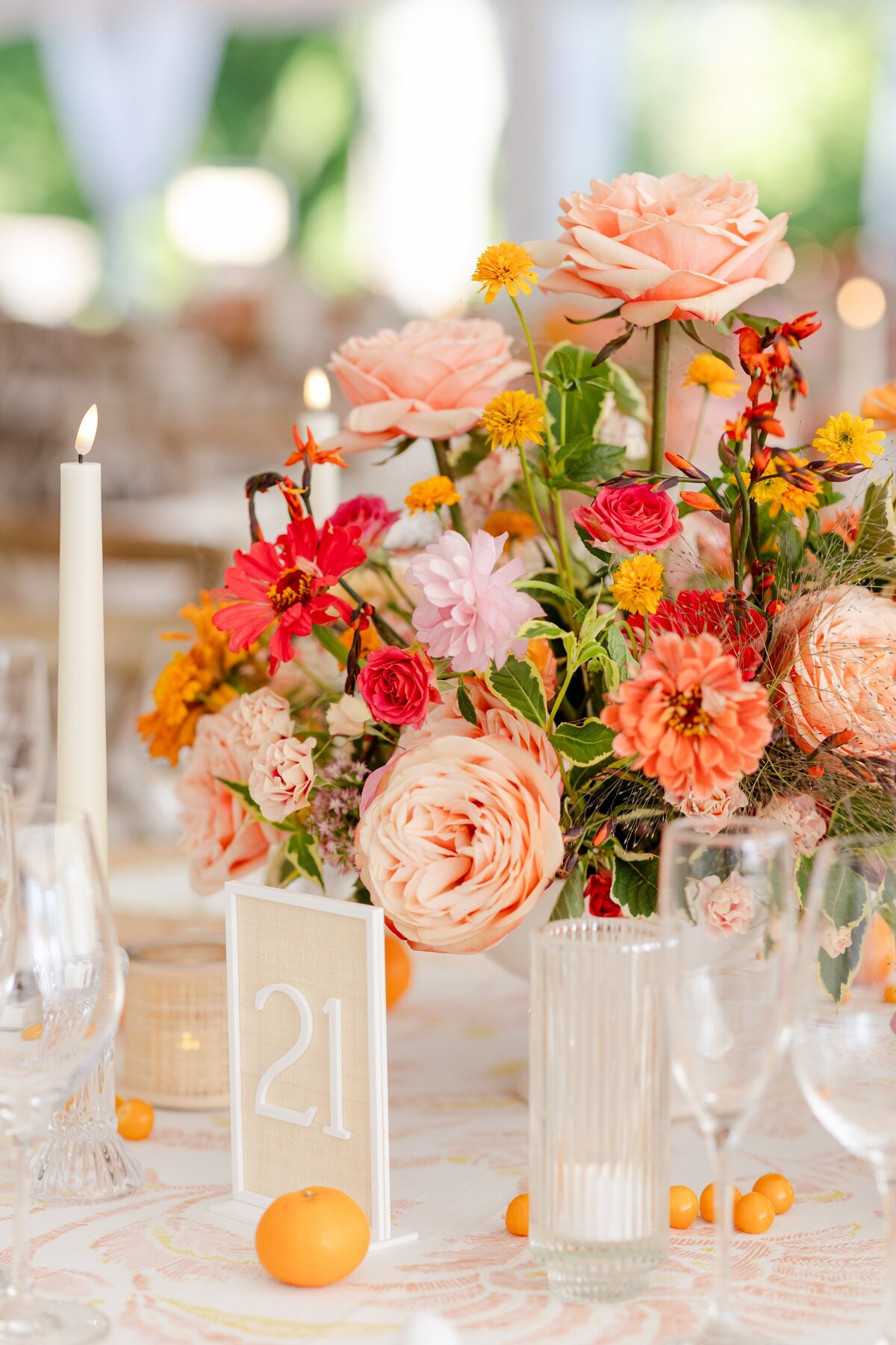 close up of orange, pink, and yellow floral centerpieces for wedding reception