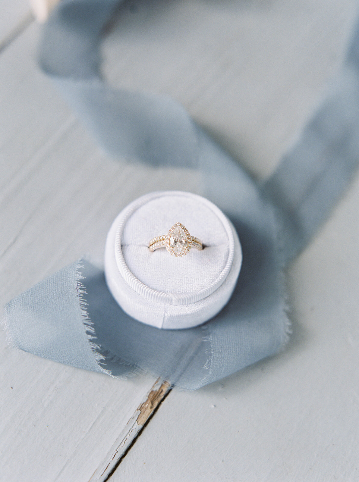 a wedding ring in a light blue box with blue ribbon