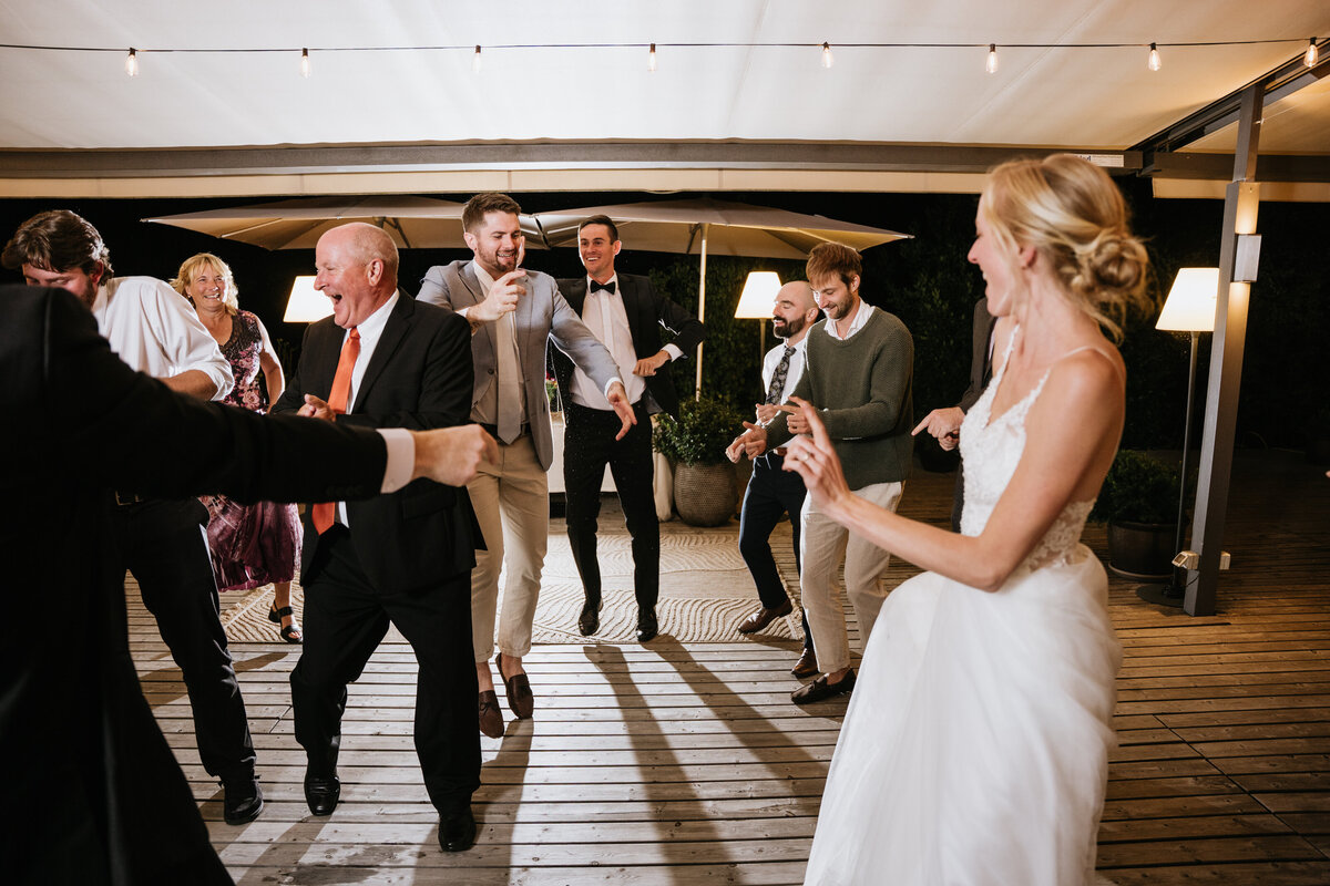 Wedding guests dancing energetically outdoors