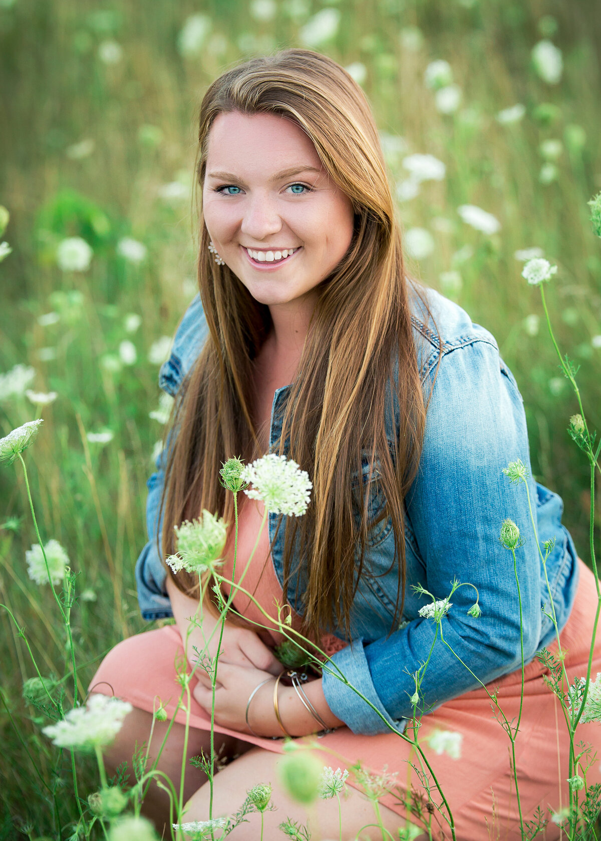 Senior pictures in a field of white wildflowers