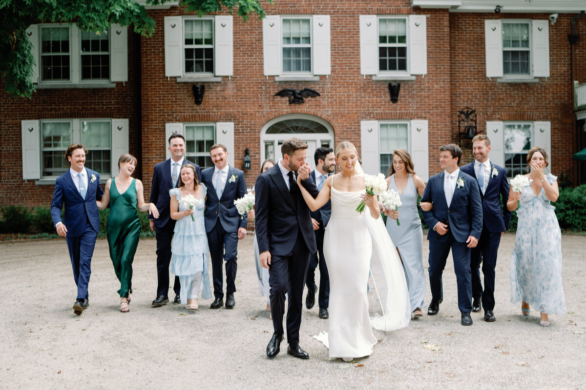 wedding couple and party walk towards wedding photographer julia luckett