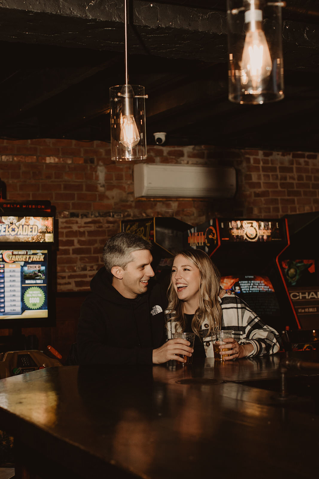 a couple sitting at a bar together laughing 