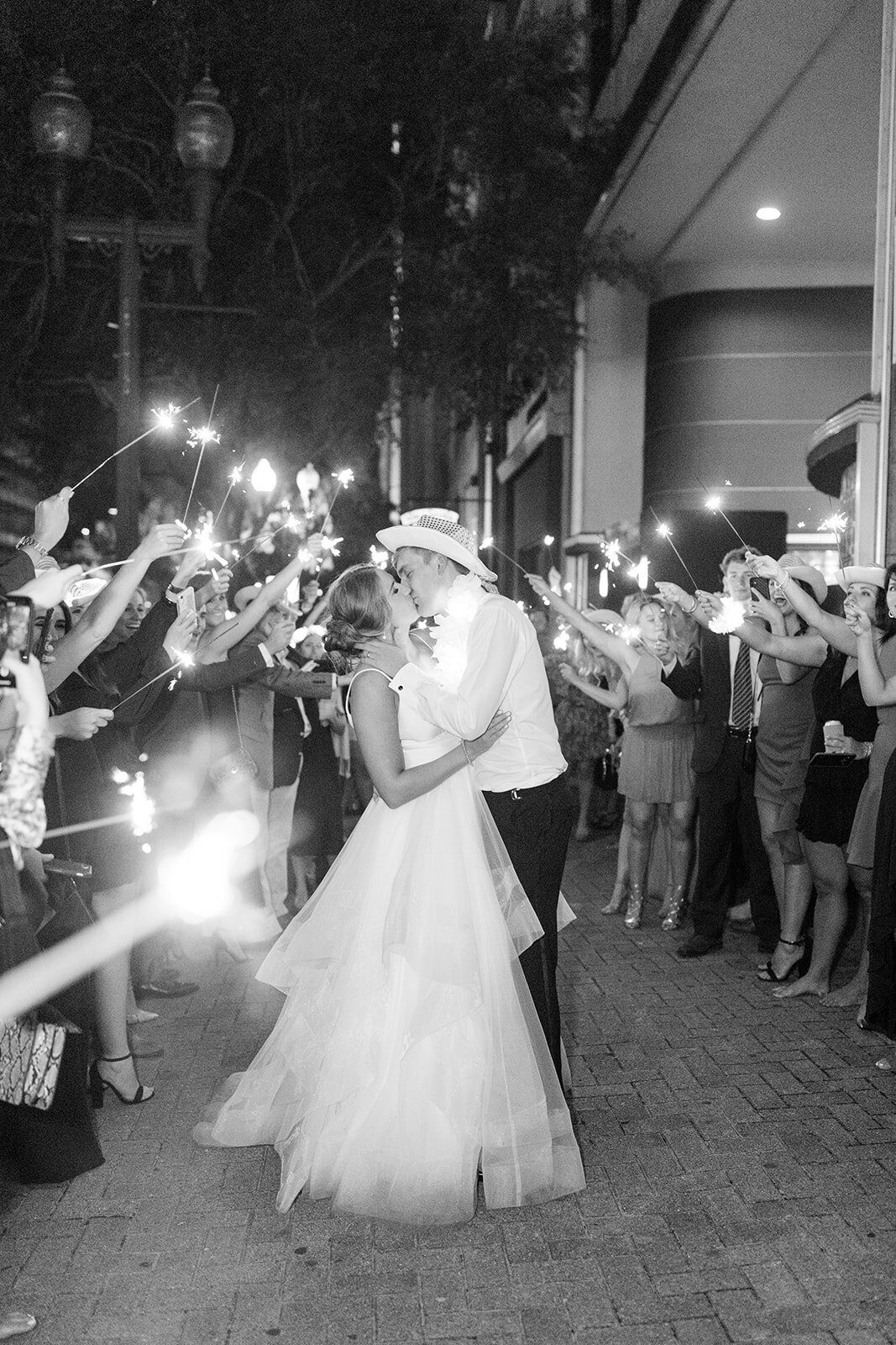 Bride and groom kiss under sparkler exit