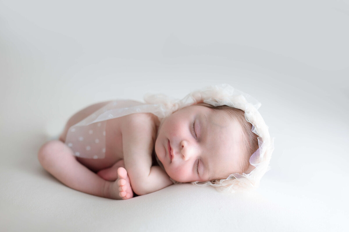 Baby girl on white with bonnet