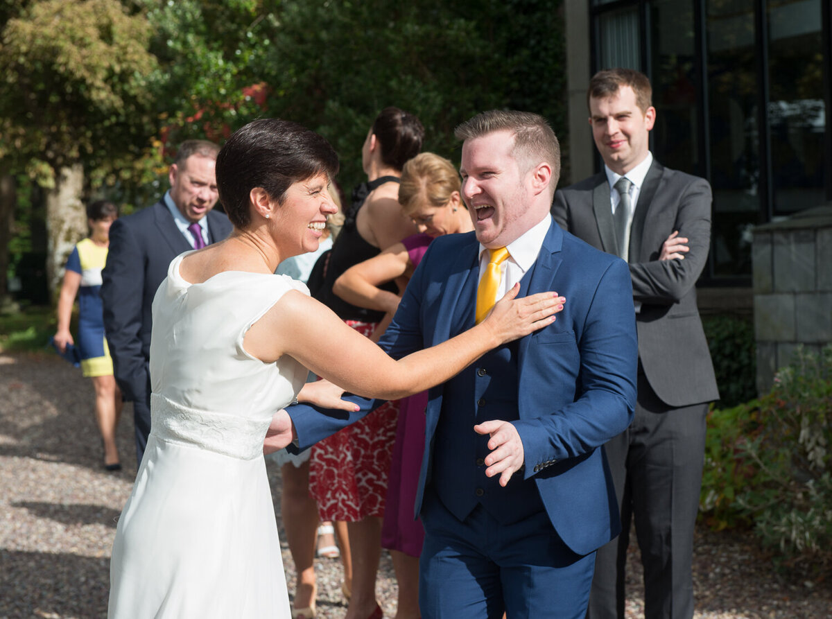 Gay bride embracing guest at wedding
