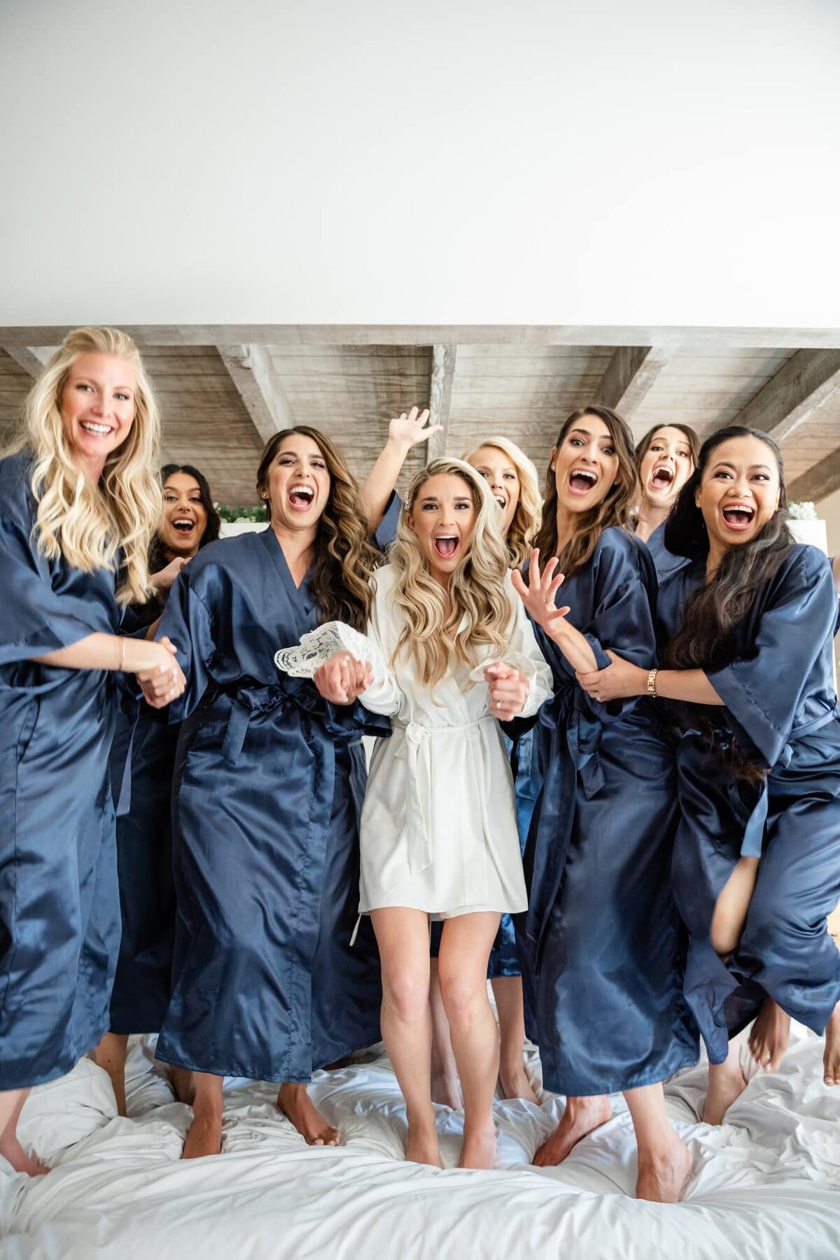 Bride and Bridesmaids jumping on a bed in excitement at Andaz Resort Scottsdale