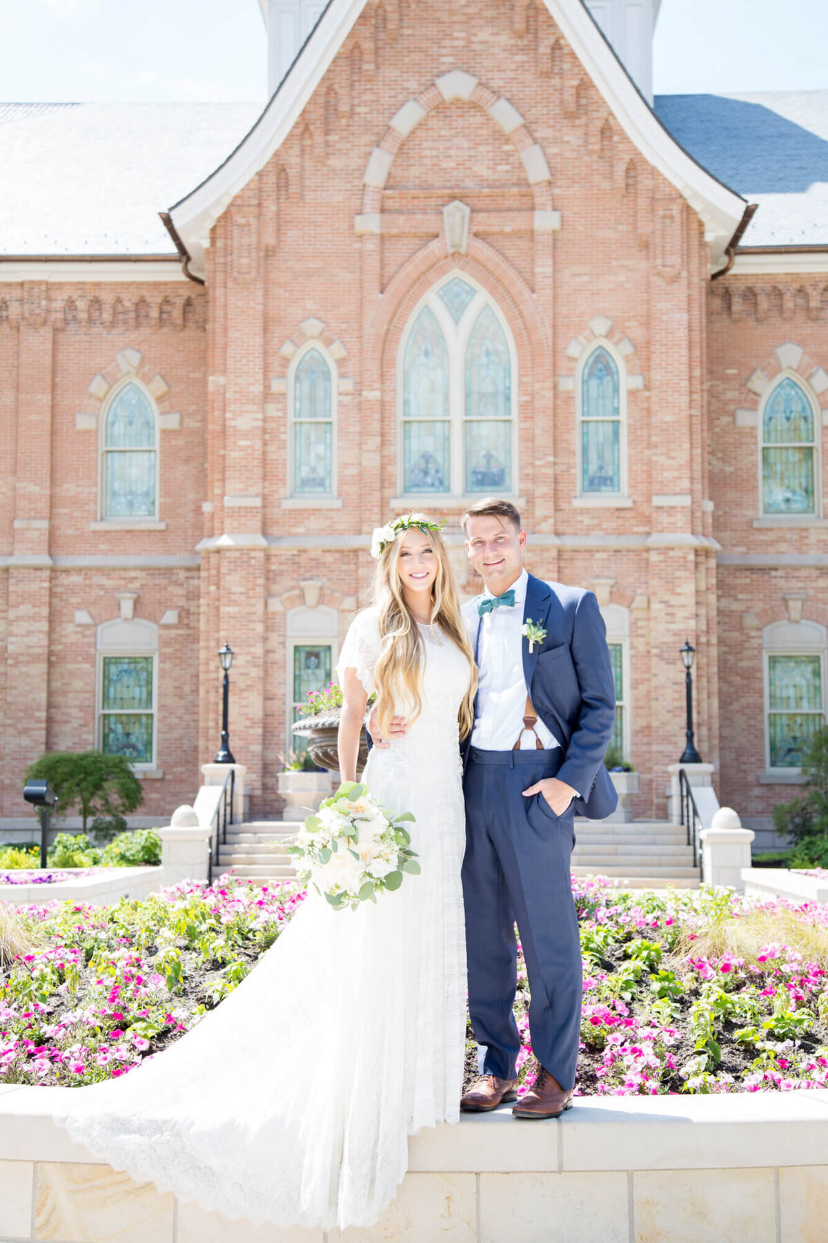 a bride and groom standing on a planter during their wedding photographyt