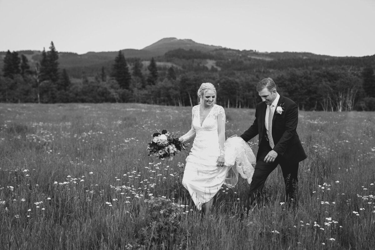 Gorgeous wedding inspiration, couple walking in field in the mountains, captured by Love and be Loved Photography, authentic and natural wedding photographer and videographer in Lethbridge, Alberta. Featured on the Bronte Bride Vendor Guide.