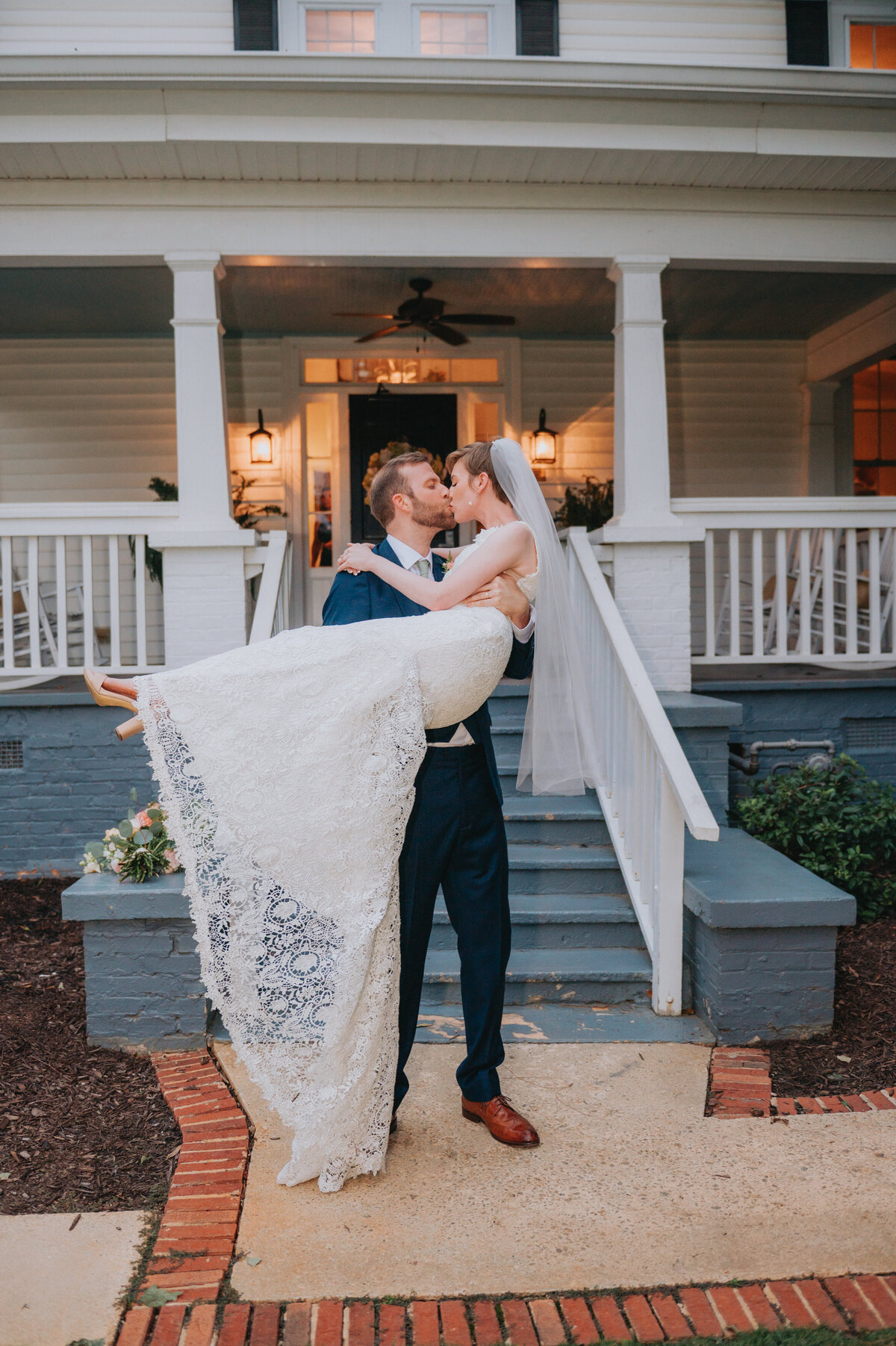One merrier picks up the other while they kiss in front of a house