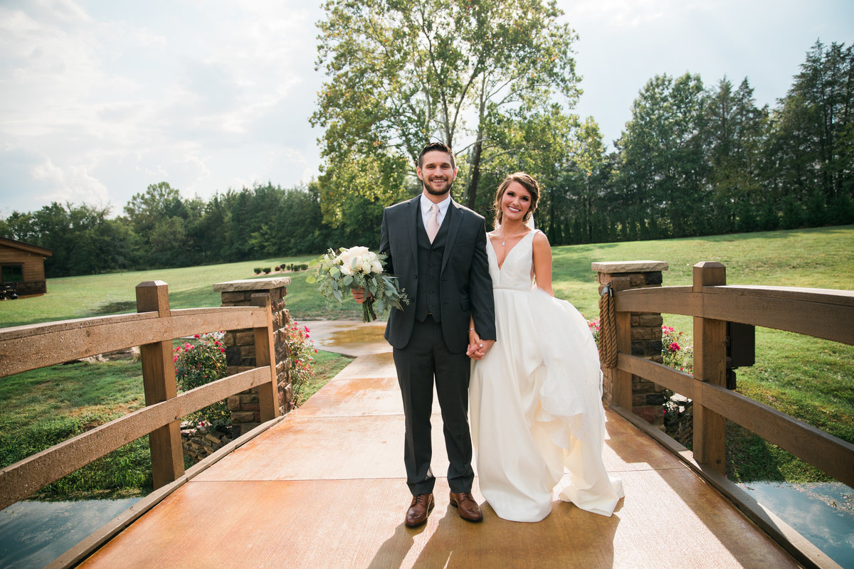 Bride and Groom standing on bridge.