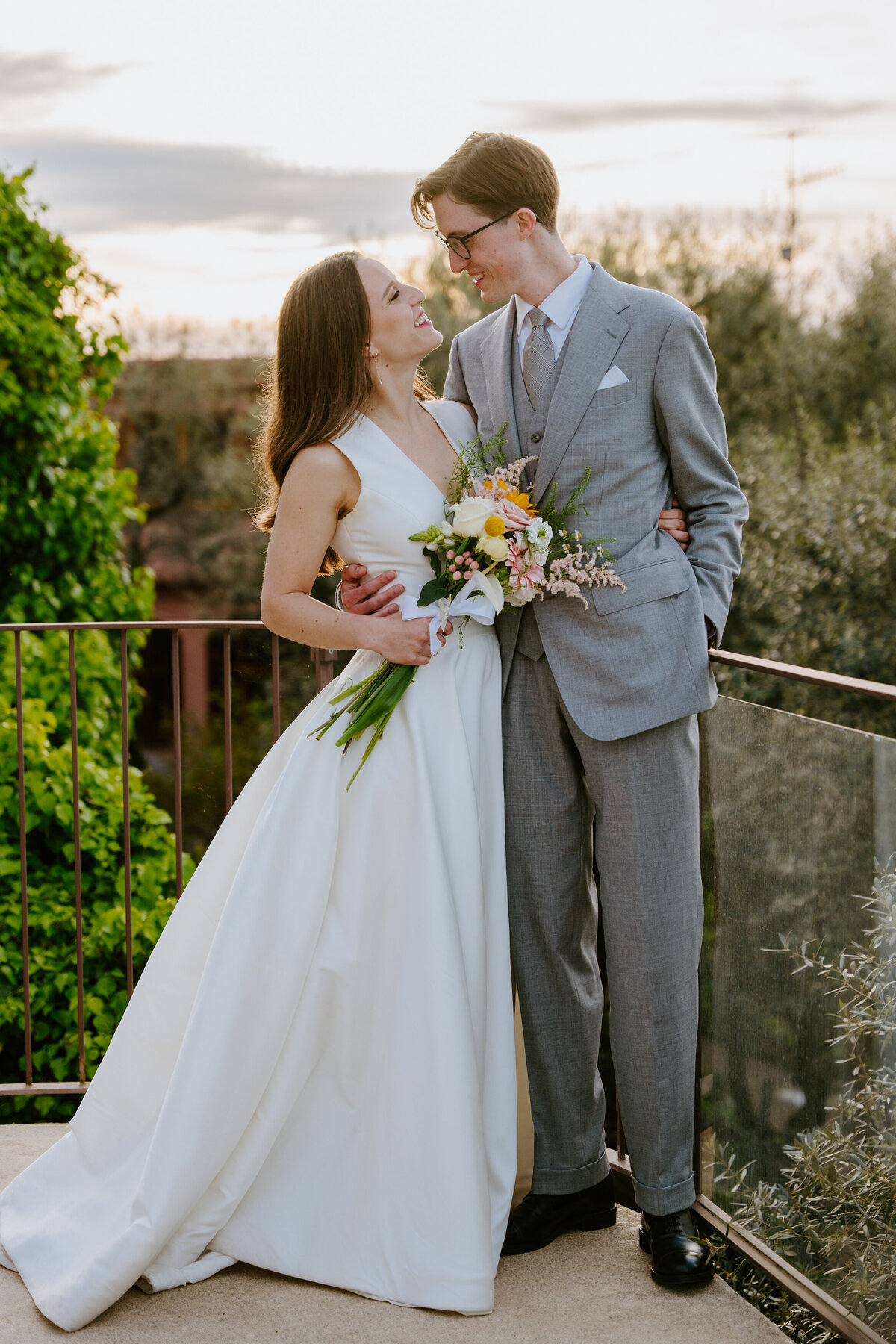 Couple hugging on terrace with ocean and mountains behind them