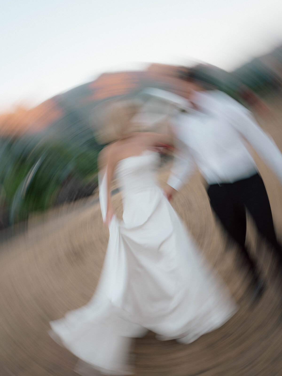Artistic motion blur of bride and groom spinning together on wedding day